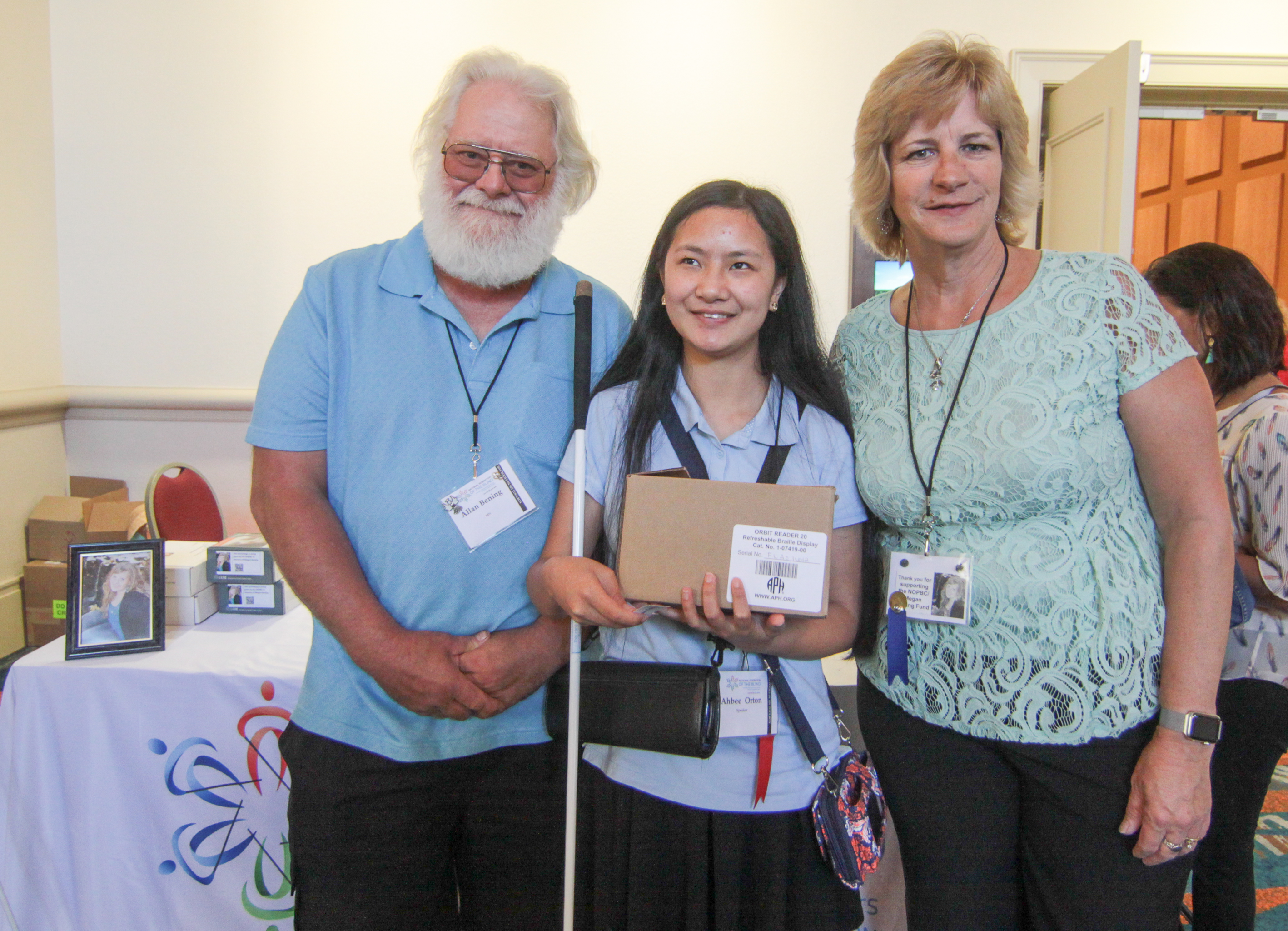 Jean and Allan Bening stand with Ahbee Orton, who holds her new Orbit Reader 20.