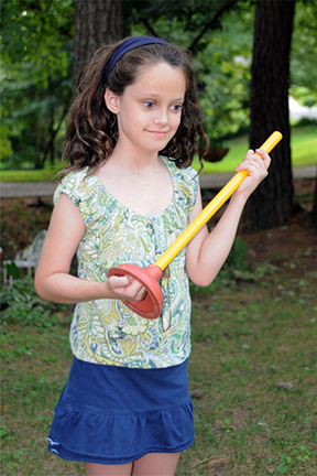 Kendra holds a plunger.