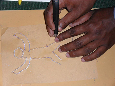 A child&rsquo;s hands are shown making a tactile drawing.