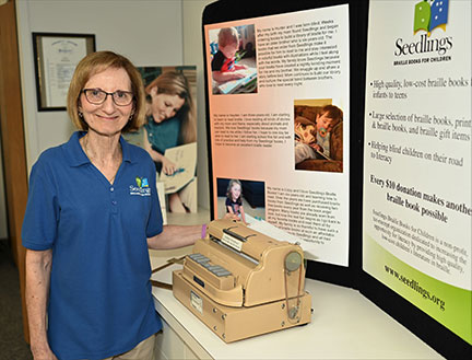 Debra Bonde stands beside the early embossing machine constructed by her father, Ray Stewart.