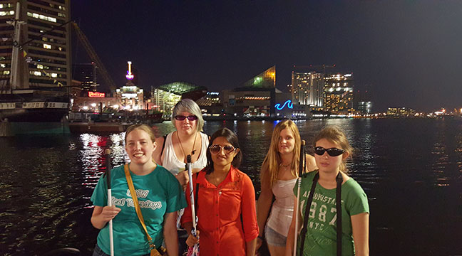 At the center of a group of girls, Mausam Mehta visits Baltimore's Inner Harbor. Check out Paths and Transitions by Mausam Mehta