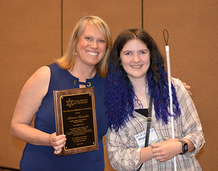 Holding her plaque, Adrienne Shoemaker stands with one of her students, Abby Duffy.