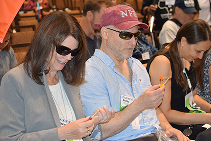 During a presentation about STEM activities, two Federationists build triangular structures with toothpicks and gumdrops.