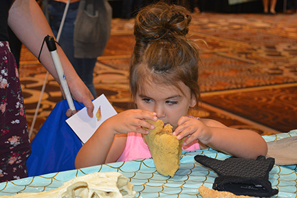 Mercedes Downs examines a sponge at the aquarium exhibit. Check out Braille Carnival: A Swimming Success