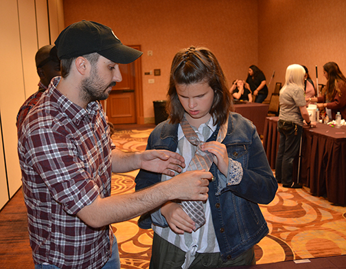 Daniel Early teaches Makenzie Love to tie a tie.