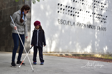 Conchita Hernandez Legorreta conducts a mobility lesson with a child in front of the Escuela para Ni&ntilde;os Ciegos in Guadalajara, Mexico.