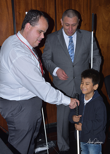 Members of the METAS team introduce a boy to the long white cane.
