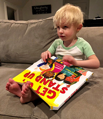 Alison Clougherty&rsquo;s son, Finn, holds a Braille book on his lap.