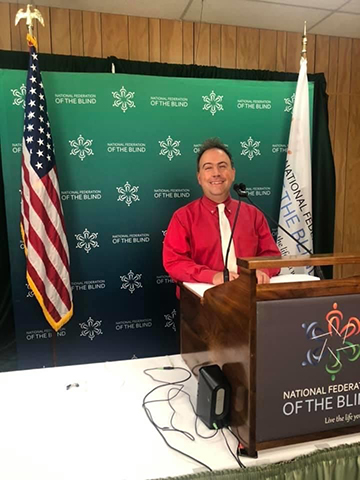 Mark Riccobono stands at the podium during the 2020 NFB National Convention.