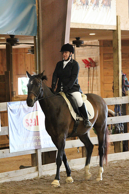 Suzanne Ament rides a horse named Quip during a horse show.