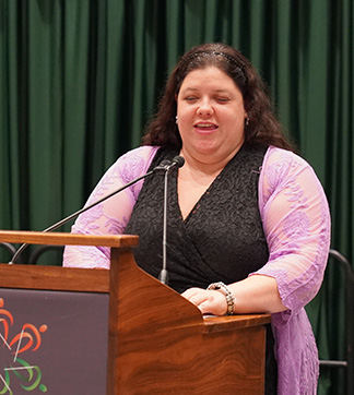Scholarship Committee Chair Cayte Mendez stands at the Banquet podium.