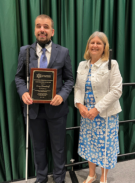 Corey Grandstaff holds his award as Robin House stands beside him 