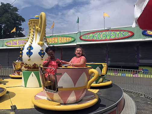 During the New Jersey NFB BELL Academy two girls enjoy the spinning cups at an amusement park.