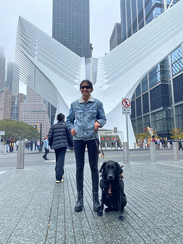Mausam Mehta and her guide dog, Mandy, stand in front of the Oculus in Lower Manhattan. 