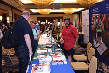 Federationists pick up literature from the Seeing Eye table in the Exhibit Hall.