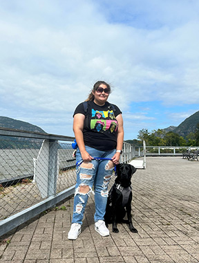 Aida Talic stands outside with her guide dog.
