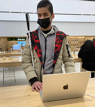 Amr examines a laptop at the Apple store.