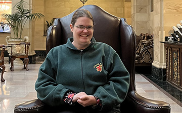 Erin Jepsen sits in a comfortable chair in a hotel lobby.