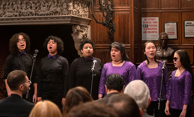 Six children sing in a music school performance.