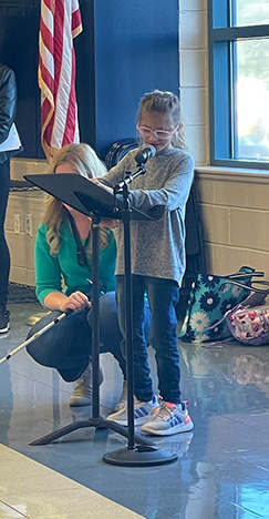 Mia Barone reads her poem at a school program.