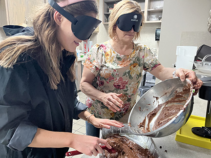 Teachers learn to make brownies under learning shades.