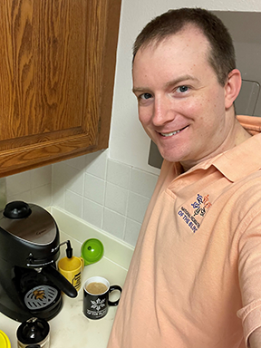 Justin Salisbury stands at the counter with his espresso machine.