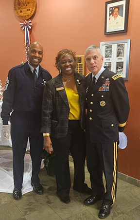 Melba Taylor stands with two men in military uniforms.