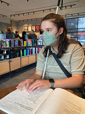 Mae Lane-Karnas reads a Braille menu at Starbucks.