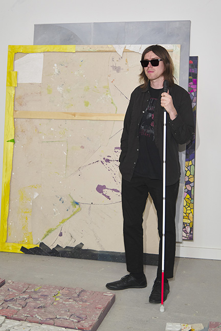 Stephen Proski stands in an art studio.