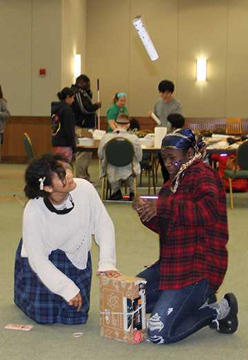Two girls launch a rocket at a Maryland NFB STEM2U program.