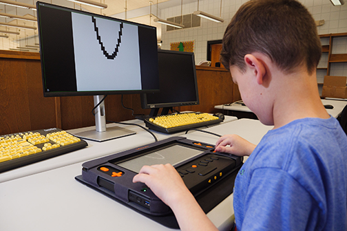 Using the Monarch, a boy makes a drawing that is visible on the monitor.