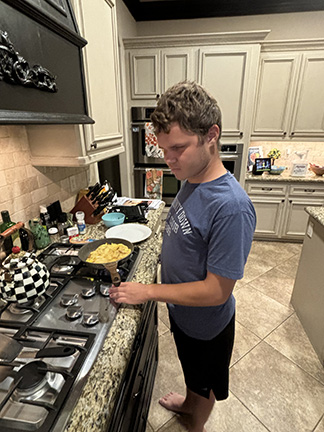 Nick Oliver adjusts the temperature on the stove.