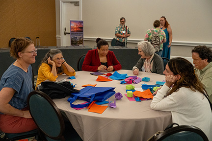 Lisamaria Martinez teaches origami folds to a group of enthusiastic learners.