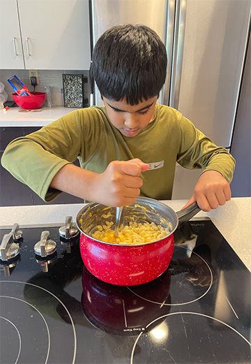 A student at Chicago NFB BELL&reg; Academy cooks macaroni and cheese for the class.
