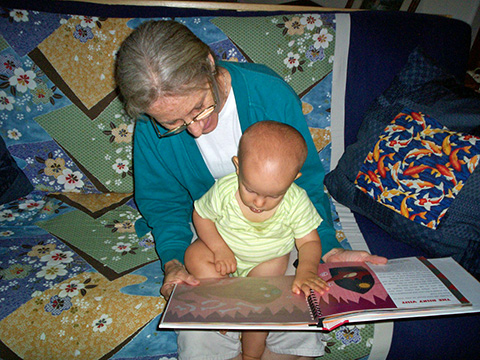 Ivan Bobnar reads a print/Braille book with Grandma.