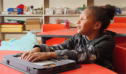 A girl sits at a desk using the Monarch.