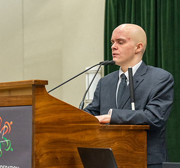 Sanho Steel-Louchart speaks from a podium.