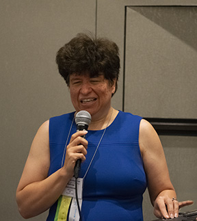 Melissa Riccobono speaks on a microphone at the NOPBC Conference.