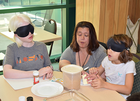 Treva Olivero prepares to bake brownies with Mercy Rao and Oriana Riccobono.