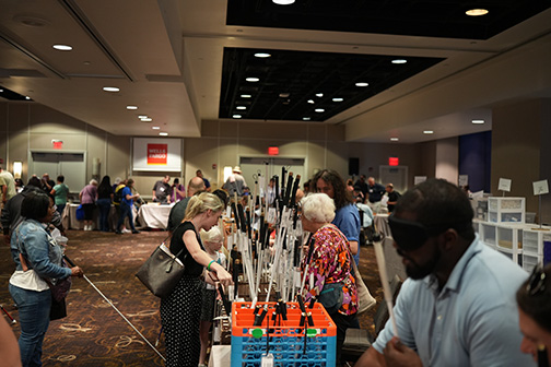 In the Exhibit Hall canes and Braille games are on display.