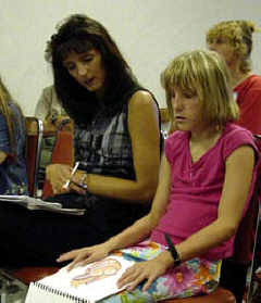 Crystal McClain of Ohio looks on while daughter, Macy, examines a tactile illustration at the Technology in the Classroom workshop conducted by Bruce McClanahan and Debbie Hartz.