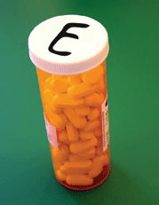 A pill bottle with a large ‘E’ written on the top with a marker.
