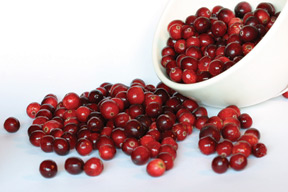 Cranberries spill out of a bowl.