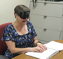 learns to read with her fingers in a Braille training session.