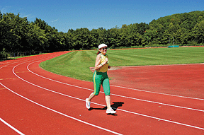 A woman jogs around a track.