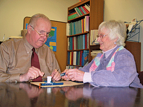 Margaret Cleary shows Dick how to use a talking glucose meter.