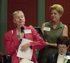 Sharon Maneki  reads the text of the award from Braille while Debbi Head holds her plaque.