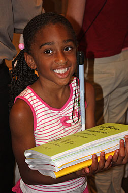 Aunya Anderson holds a stack of the books she has gathered at the Braille Book Flea Market.