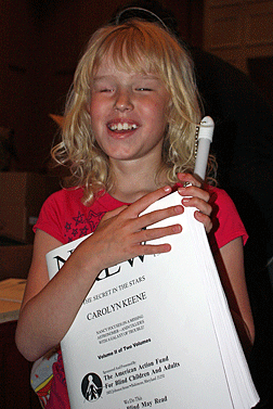 Katie Morgan proudly holds her Nancy Drew book at the Braille Book Fair.