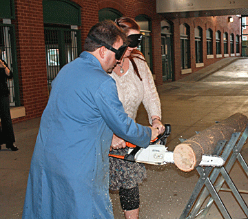 Mark Riccobono teaches Amy Lund to use a chain saw.
